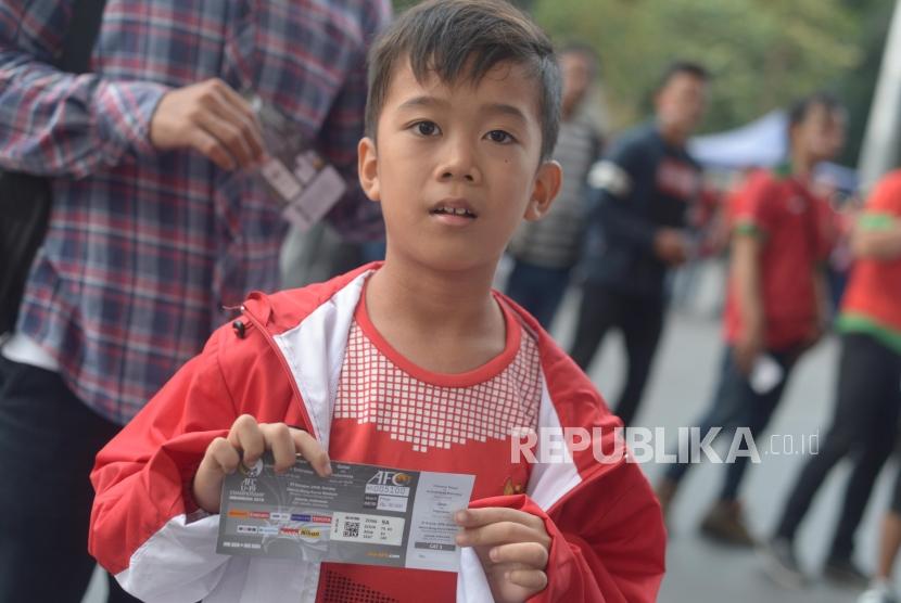 Penonton Sepak Bola. Pendukung Sepakbola menunjukan tiket pertandingan Indonesia melawan  Qatar dalam Piala AFC U-19 di kawasan Stadion Utama Gelora Bung Karno, Jakarta, Ahad (21/10).