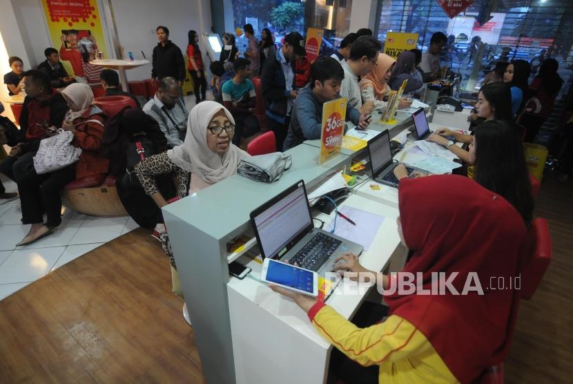 Petugas melayani antrian warga untuk melakukan registrasi ulang kartu SIM prabayar di Galeri Indosat, Kota Bogor, Jawa Barat, Rabu (28/2).