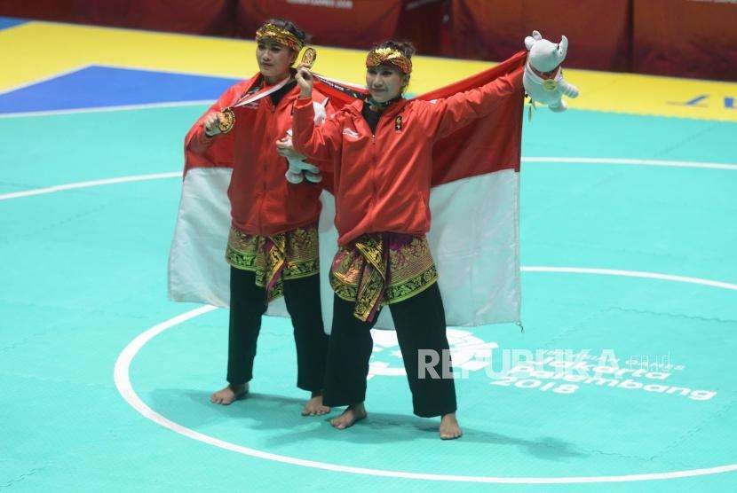 Pesilat Indonesia Ayu Sidan Wilantari dan Ni Made Dwiyanti memperlihatkan medali emas usai pertandingan cabang olahraga silat Asian Games 2018 kategori ganda putri di Padepokan Pencak Silat TMII, Jakarta, Rabu (29/8).