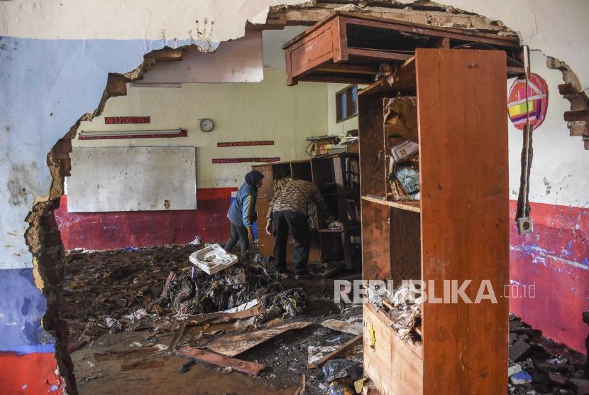 Sejumlah guru mengevakuasi fasilitas sekolah pascabanjir bandang di SDN 106 Ajitunggal Ujungberung, Kota Bandung, Selasa (2/4).