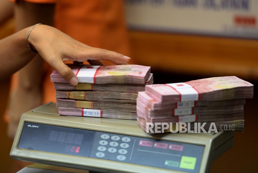 Transaksi Mata Uang Lokal. Petugas menghitung mata uang Rupiah di jasa penukaran uang, Jakarta, Senin (11/12).