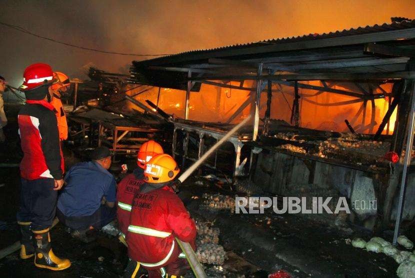 Pertugas pemadam kebakaran berusaha memadamkan api yang menghanguskan Pasar Gedebage, Kota Bandung, Senin (3/9).