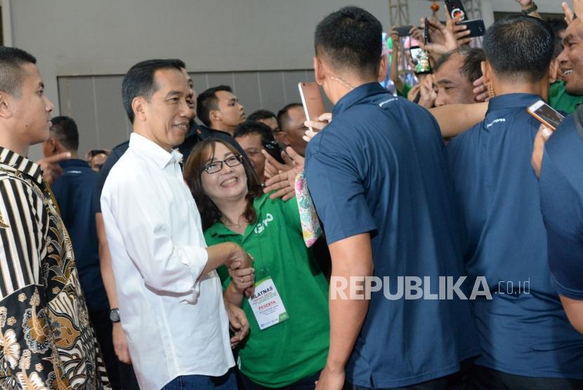 Presiden Joko Widodo (tengah) melayani permintaan swafoto oleh pengemudi online disela-sela Silatnas Keluarga Besar Pengemudi Online di Jakarta, Sabtu (12/1).