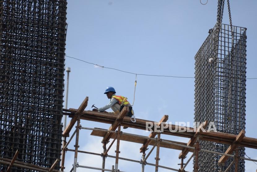 Pekerja beraktivitas dipembangunan gedung bertingakat di Jakarta, Ahad (30/12).