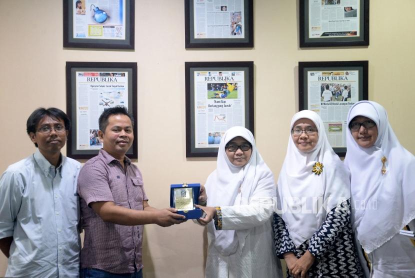  Ketua Bidang Perempuan dan Ketahanan Keluarga (BPKK) DPP PKS Wirianingsih (ketiga kanan) memberikan cinderamata kepada Waredpel Republika Heri Ruslan (kedua kiri) saat berkunjung ke kantor Republika, Jakarta, Senin (18/12).
