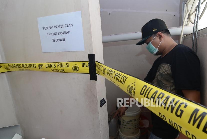 Olah TKP pabrik sabu. Petugas kepolisian memeriksa tempat produksi pabrik Sabu di Kalideres, Jakarta Barat, Senin (24/6).