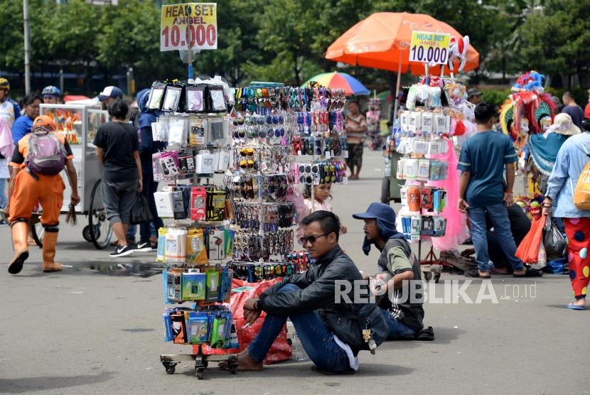 Pedagang kaki lima (PKL) berjualan di jalan saat pelaksanaan Hari Bebas Kendaraan Bermotor di kawasan Bundaran HI, Jakarta, Ahad (17/2).