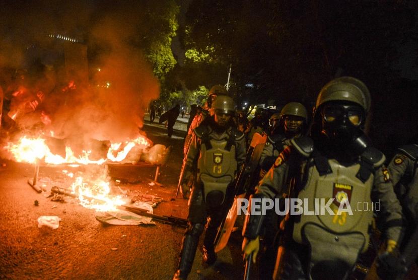 Sejumlah anggota kepolisian berjaga saat terjadi kericuhan di kawasan Palmerah, Senin (30/9).