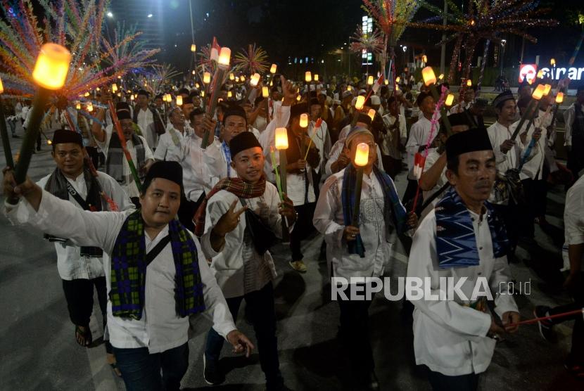 Sejumlah peserta mengikuti pawai obor elektrik pada Jakarta Muharram Festival di Jalan MH Thamrin, Jakarta, Sabtu (31/8).