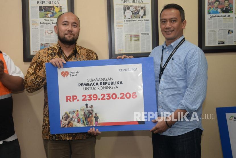 Dirut Republika Media Mandiri Agoosh Yoosran menyerahkan sumbangan pembaca Republika untuk Rohingya kepada Corporate Secretary Rumah Zakat Branata (kiri) di Kantor Republika, Jakarta, Jumat (20/4).