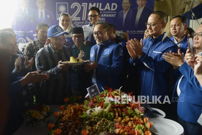 Ketua Umum PAN Zulkifli Hasan (tengah) menyerahkan potongan nasi tumpeng kepada Ketua Dewan Kehormatan Amien Rais disaksikan Sekjen Eddy Soeparno saat perayaan HUT ke-21 PAN di Pluit, Jakarta, Jumat (23/8/2019).