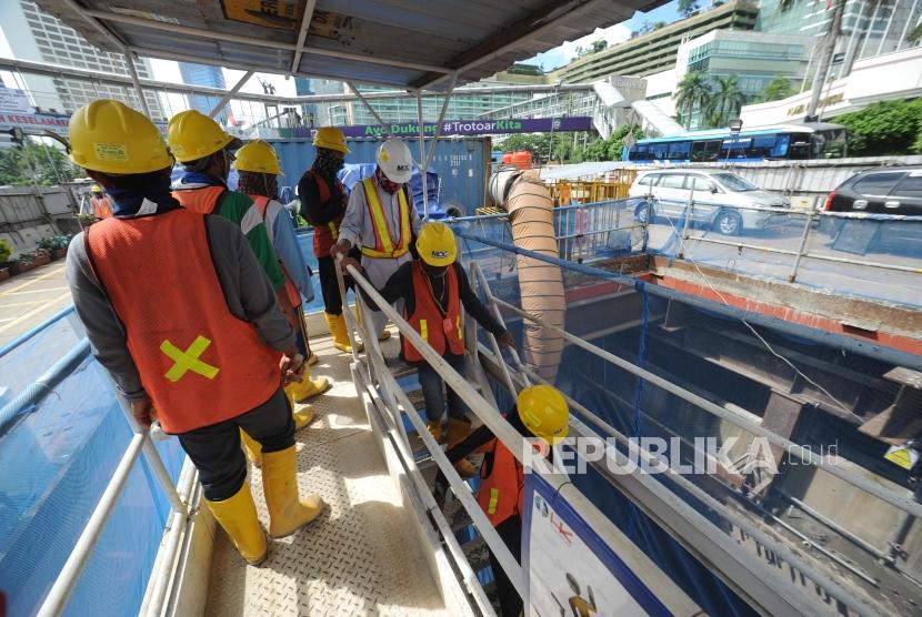 Pekerja MRT  memasuki area proyek MRT  saat peninjauan Dirjen  Binwasnaker  dan K3 Sugeng Priyanto  ke proyek MRT di kawasan Bundaran HI, Jakarta, Jumat (22/12).