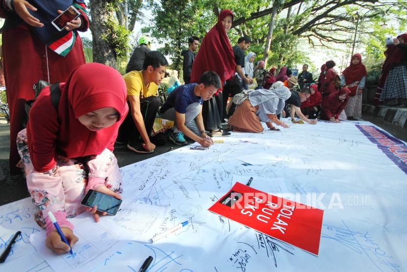 Masyarakat dan para aktivis yang tergabung dalam Aliansi Gerakan Peduli Perempuan menandatangani pernyataan sikap saat aksi menolak Rancangan Undang-Undang Penghapusan Kekerasan Seksual (RUU PKS) di Car Free Day (CFD) Dago, Kota Bandung, Ahad (21/7).
