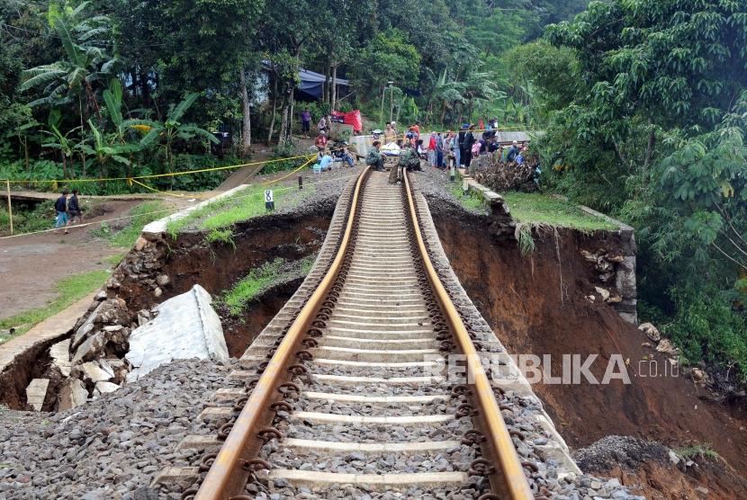 Kondisi jalur kereta api jurusan Sukabumi-Bogor yang menggantung akibat pondasi longsor di Kampung Maseng, Cijeruk, Kabupaten Bogor, Jawa Barat, Selasa (6/2).