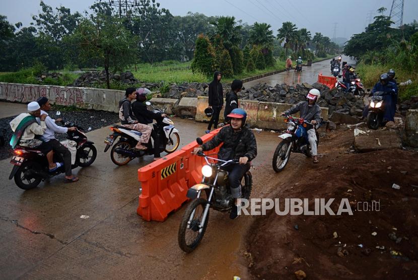 Pengendara motor melewati blokade Jalan Regional Ring Road (R3), Katulampa, Bogor, Jawa Barat.