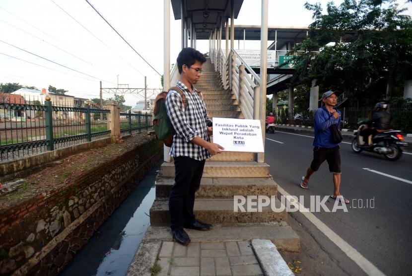 Sejumlah aktivis Koalisi Pejalan Kaki saat melakukan aksi Tamasya Trotoar di Jalan I Gusti Ngurah Rai, Klender, Jakarta Timur, Jumat (7/12).