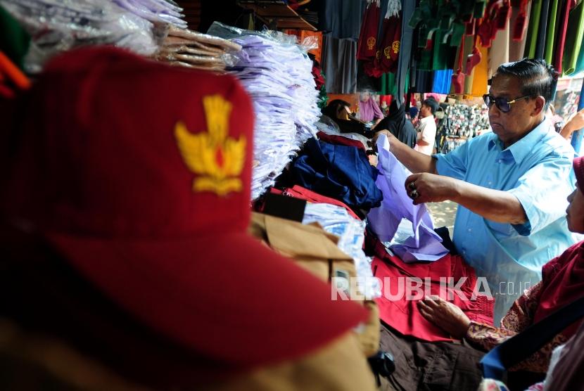 Warga memilih seragam sekolah di Pasar Jatinegara, Jakarta Timur, Rabu (4/7).