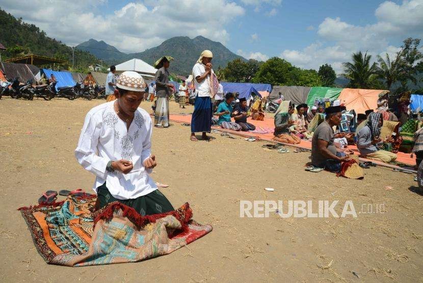 Korban bencana gempa bumi Lombok berdoa usai menunaikan ibadah shalat Jumat di pengungsian, Lombok Utara, Nusa Tenggara Barat, Jumat (10/8).