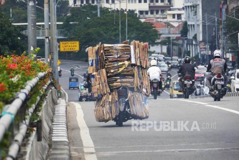 Sebuah sepeda motor dengan bermuatan tumpukan kardus bekas melintas di kisaran fly over Senen Jakarta, Selasa (4/7). Membawa barang dengan kapasitas berlebih pada sepeda motor dapat membahayakan dipengendara dan pengguna jalan lainnya. Foto: darmawan.