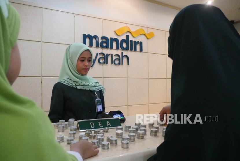 Via nasabah cilik Bank Syariah Mandiri (BSM) bersama ibunya menyetorkan uang koin hasil tabungannya di teller BSM Cabang Thamrin Jakarta, Rabu (16/5).