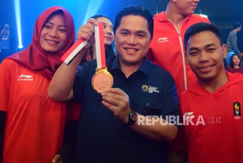 Ketua Panitia Asian Games Erick Thohir memegang medali emas bersama atlet Indonesia untuk Asian Games 2018 saat konser 50 hari menuju Asian Games 2018 di Jakarta, Sabtu (30/6).