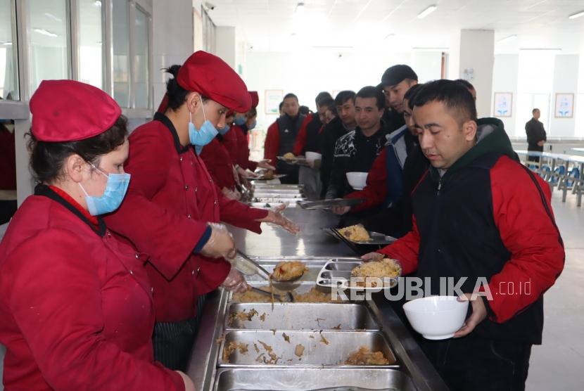 Para peserta didik kamp pendidikan vokasi etnis Uighur di Kota Kashgar, Daerah Otonomi Xinjiang, Cina, antre makan siang di kantin saat jam istirahat, Jumat (3/1/2019).