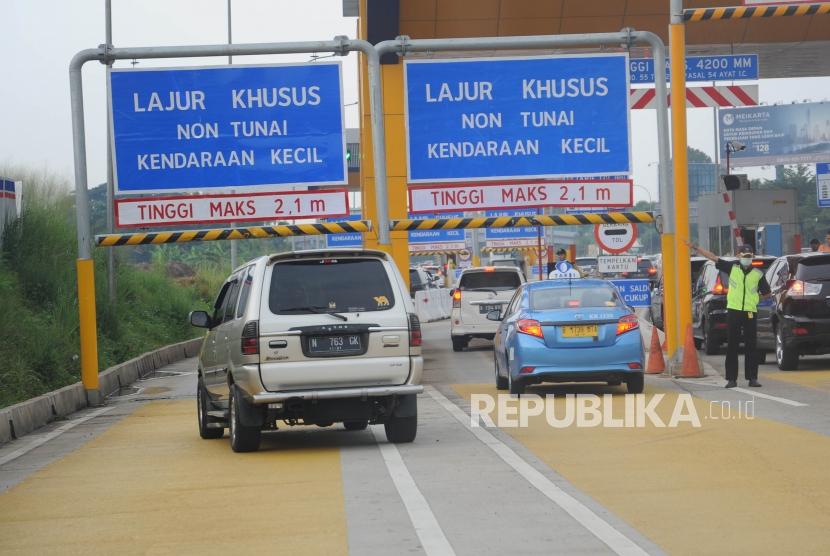 Petugas pintu tol Kunciran 2 mengarahkan kendaraan ke pintu tol, Tangerang,Banten, Ahad (15/4).