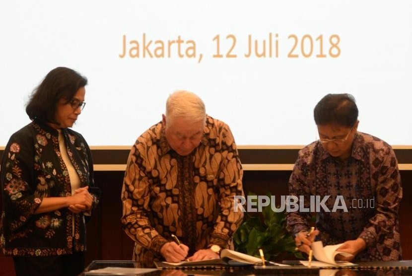 President Director of PT Inalum Budi Gunadi Sadikin (right) and CEO Freeport-McMoran Inc Richard Adkerson sign the Head of Agreement (HoA) for the divestment process in PT Freeport Indonesia (PTFI) witnessed by Finance Minister Sri Mulyani (left) at Finance Ministry Office, Jakarta, Thursday (July 12).