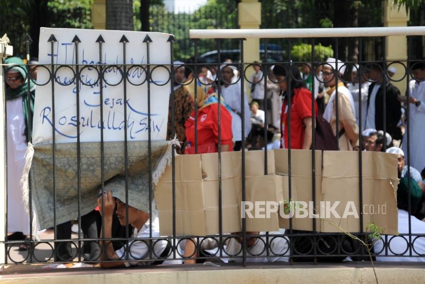 Massa   HTI saat menunggu hasil sidang pembacaan putusan gugatan Hizbut Tahrir Indonesia (HTI) di Pengadilan Tata Usaha Negara (PTUN), Jakarta, Senin (7/5).