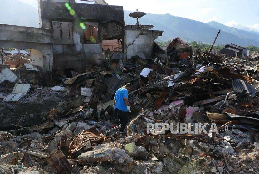 Alat berat bantuan United Tractor Group mengengevakuasi reruntuhan rumah korban gempa di Palu, Rabu (3/10). UT Group memulai pada tahap evakuasi dengan mendatangkan sejumlah alat berat berupa 4 unit excavator, 1 unit bulldozer dan 1 unit lowboy yang beroperasi di lokasi gempa di  Kelurahan Balaroa, Palu, Sulawesi Tengah. 
