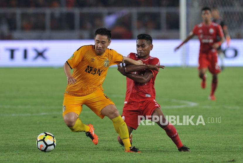 Pemain Persija Jakarta Ramdani Lestaluhu (kanan) berebut bola dengan pemain Bhayangkara FC Lee Yujun saat laga pembuka Liga 1 Gojek Traveloka di Stadion Gelora Bung Karno, Senayan, Jakarta, Jumat (23/3).