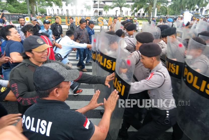 Polisi berusaha menghadang peserta aksi yang semakin anarkis saat simulasi pengamanan Pilkada serentak di depan Gedung Sate, Kota Bandung, Jumat (9/2).