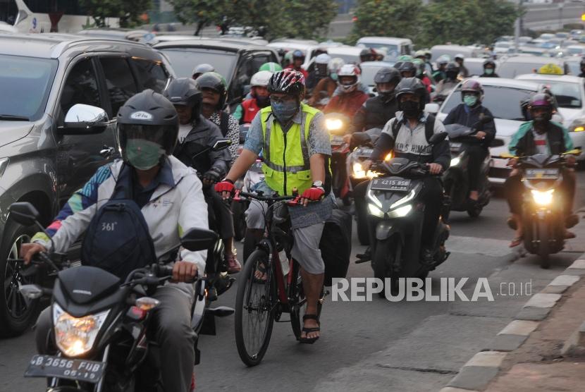 Kerugian AKibat Kemacetan Jakarta.Pengendara sepeda terjebak macet di kawasan Gatot Subroto, Jakarta Pusat, Selasa (2/7).