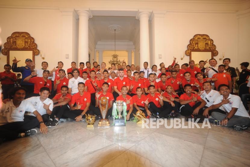  Gubernur dan Wakil Gubernur DKI Jakarta Anies Baswedan  dan Sandiaga Uno berfoto bersama  dengan kesebelasan dan official Persija jakarta usai menerima tim persija yang melakukan konvoi kemenangan dari SUGBK menuju Balaikota Jakarta, Ahad (18/2).