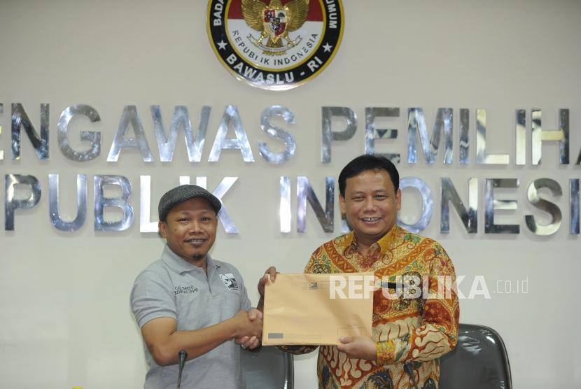 Kornas JPPR, Sunanto,(kiri) menyerahkan berkas pendaftaran sebagai pemantau kepada Ketua Bawaslu, Abhan,(kanan) usai diskusi yang dilakukan di gedung Bawaslu, Jakarta, Selasa (27/3).