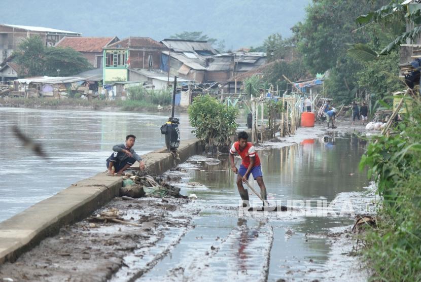 A number of residents cooperate to clean up the remaining flood mud in Bantaran Citarum street, Bojongsoang District, Bandung Regency, December 18, 2017.