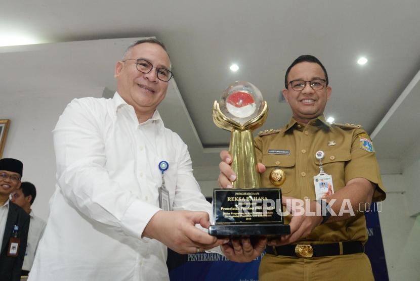 Kepala Badan Pengembangan dan Pembinaan Bahasa Kementerian Pendidikan dan Kebudayaan Dadang Suhendar(kiri)   bersama  Gubernur DKI  Jakarta Anies Baswedan (kanan)  menunjukan piala reksa bahasa  dalam acara penghargaan  a Badan Pengembangan dan Pembinaan Bahasa di Jakarta, Senin (10/12).