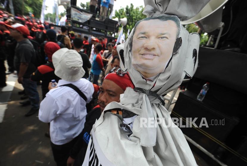 Demo. Buruh membawa foto Gubernur DKI Jakarta Anies Baswedan dalam aksi demo buruh di depan Balaikota DKI Jakarta, Jumat(10/11). Aksi unjuk rasa ini bertujuan menolak upah murah dan meminta Gubernur DKI Jakarta Anies Baswedan untuk merevisi UMP DKI Jakarta