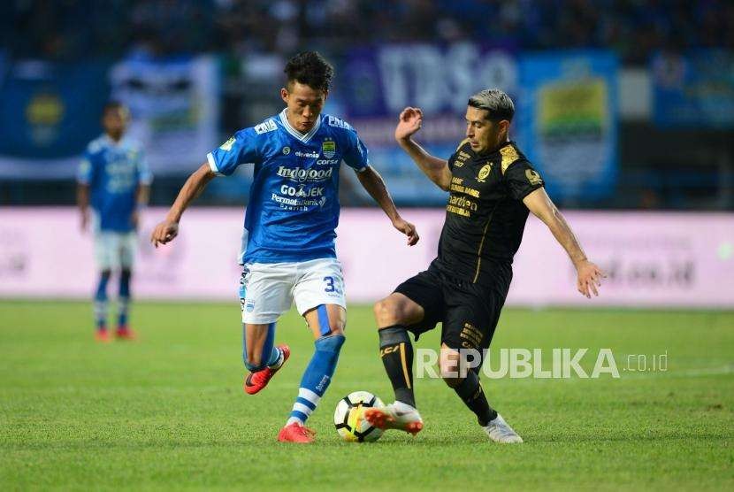 Gelandang Persib Oh Inkyun diadang gelandang Sriwijaya FC Esteban Vizcarra (kanan) pada pertadingan Gojek Liga1 2018 di Stadion Gelora Bandung Lautan Api (GBLA) di Bandung, Sabtu (4/7).