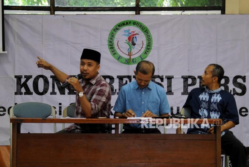 Sekjen Federasi Serikat Guru Indonesia (FSGI) Heru Purnomo (tengah) didampingi Wakil Sekjen FSGI Satriwan Salim (kiri) dan Bendahara FSGI Slamet Maryanto (kanan) memberikan penjelasan saat konferensi pers di Gedung LBH Jakarta, Ahad (3/12).