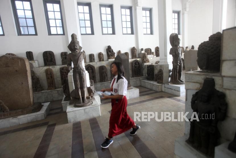 Seorang siswa Sekolah Dasar (SD) mengamati koleksi artefak patung saat belajar bersama di Museum Nasional, Jakarta, Kamis (18/10).