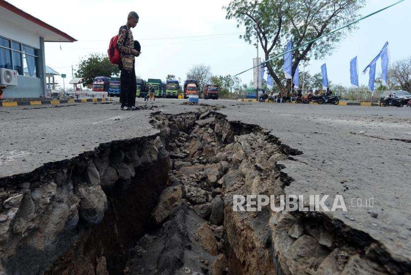 Warga melihat kondisi area parkir ruang tunggu yang retak akibat gempa di Pelabuhan Kayangan, Lombok Timur, NTB, Selasa (21/8).