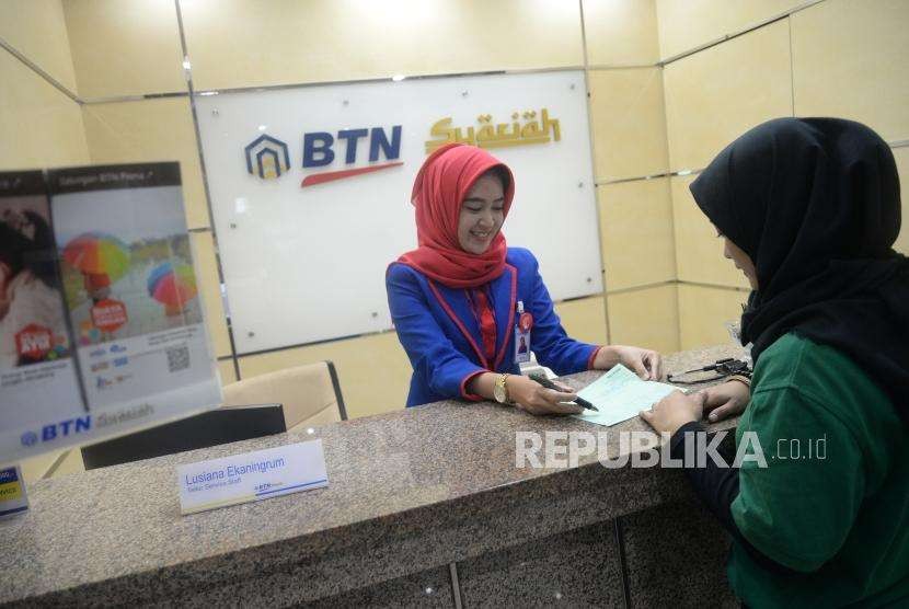 Target Petumbuhan Aset. Petugas melayani transaksi nasabah di kantor layanan BTN Syariah, Jakarta, Selasa (20/3).