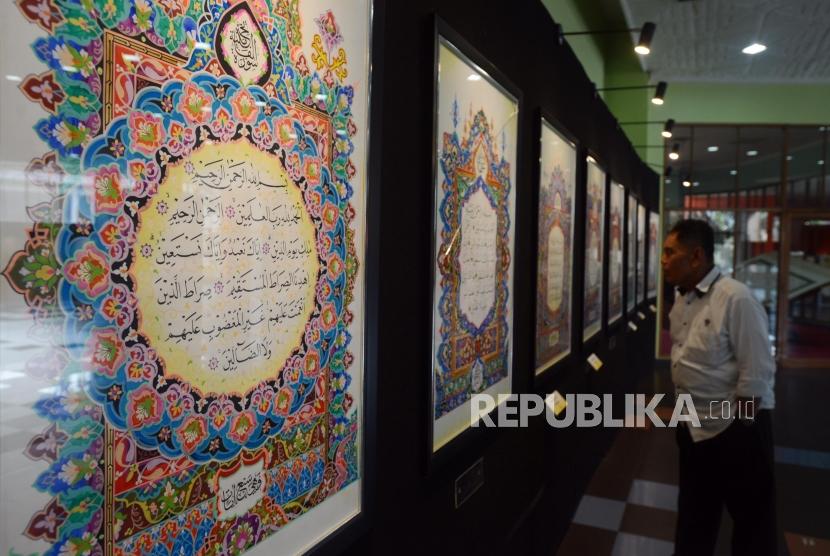 Pengujung melihat lukisan kaligrafi yang dipamerkan pada Festival Seni Kaligrafi Islam Indonesia di Gedung Bayt Al-Quran TMII, Jakarta, Senin (14/1).