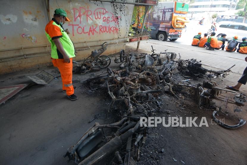Petugas PPSU melihat motor yang hangus terbakar di kawasan slipi yang hangus terbakar pasca aksi demo pelajar tolak UU KPK hasil revisi dan RKUHP di kawasan Petamburan, Jakarta, Kamis (26/9/2019).