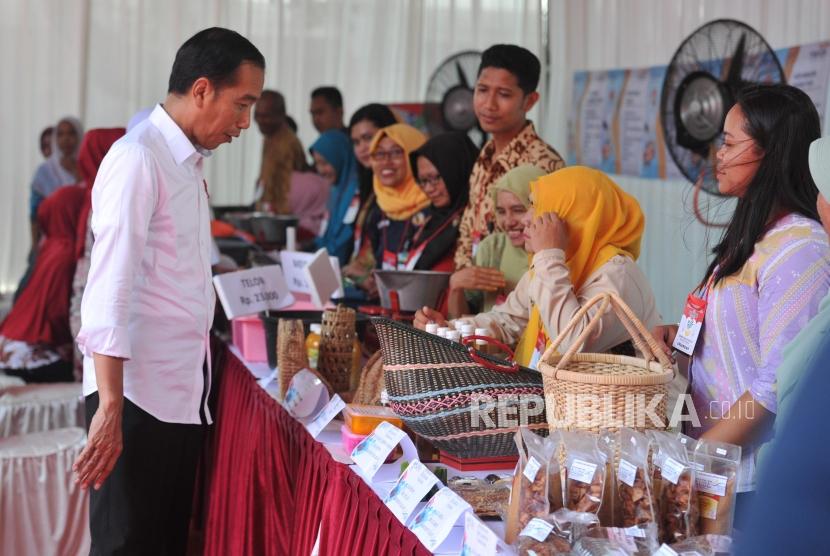 Presiden Joko Widodo meninjau stan warga sebelum menyerahkan bantuan sosial Program Keluarga Harapan. (Republika/Edwin Dwi Putranto)
