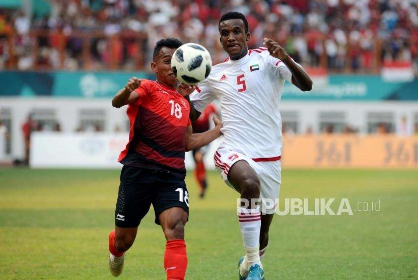 Pesepakbola Indonesia Irfan Jaya (kiri) bersama Pesepakbola Uni Emirat Arab Esmail Alali mengejar bola pada pertandingan babak 16 besar cabang sepak bola Asian Games 2018 di Stadion Wibawa Mukti, Cikarang, Bekasi, Jawa Barat, Jumat (24/8).