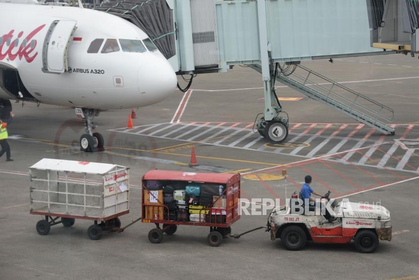 Petugas masukan barang milik penumpang ke bagasi pesawat di Bandara Internasional Soekarno,-Hatta, Tanggerang,Banten, Kamis (7/2).