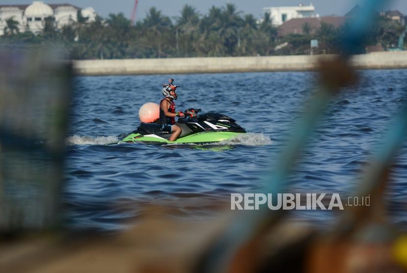 Wisatawan bermain jetski di kawasan Muara Angke, Jakarta Utara, Ahad (1/9/2019).