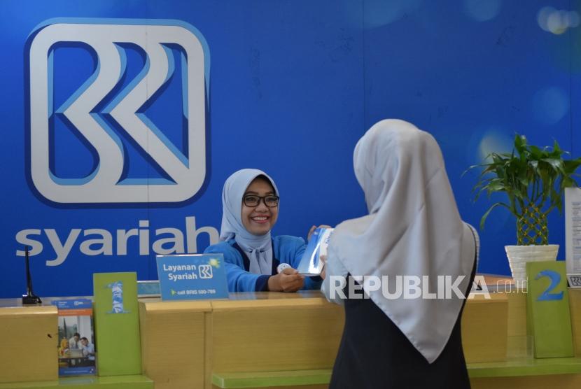 Petugas melayani transaksi nasabah di kantor layanan BRI Syariah, Jakarta, Rabu (24/10).